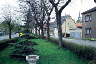 zwei parallel verlaufende Straßen, dazwischen Grünsteifen mit Bäumen