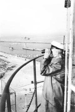 Leuchtturmwärter blickt auf die Molen des Hafens von Warnemünde