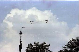 Berlin: Fallschirmspringer über der Stadt; mit Turmspitze