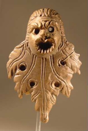 Komische Maske, an ein vierfach durchbohrtes Weinblatt angesetzt