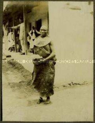Ältere Massai-Frau an einer Hausecke