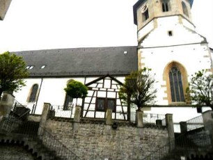 Ansicht von Süden mit Kirche (Chorturm im Kern Romanisch-Gotisch überarbeitet - Langhaus Gotisch mit späterer Überformung) über Kirchhofmauer (Wehrgang im 18 Jh abgetragen) über Kirchhofmauer
