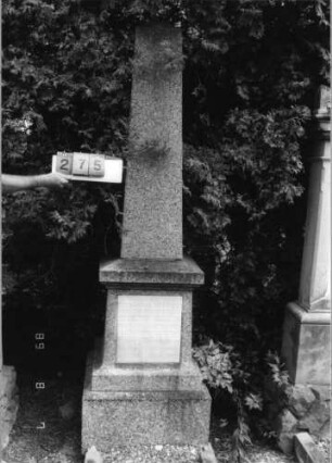 Grabstein 275 (Index: 99797053) Material: Granit, weiße Marmorplatte Zustand: gut Maße HxBxT: 230x57x55 cm Beschreibung: postamentierter Obelisk, rechteckige Schriftplatte: Grabstein 275