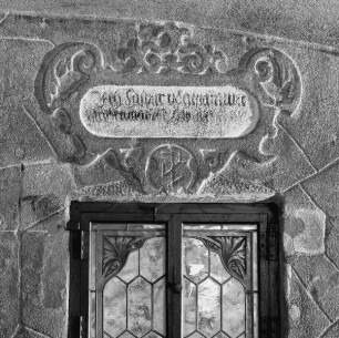Bauinschrift in Beschlagwerkkartusche, darunter Steinmetzzeichen