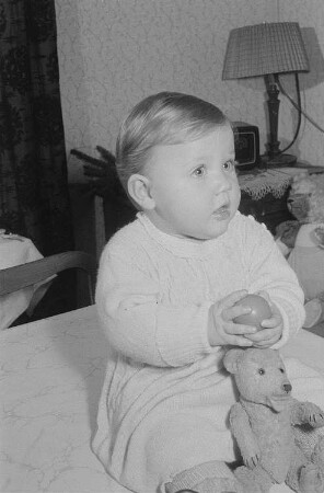 Ein mit Ball und Teddybären (Baby-Teddybär der Firma Steiff) spielendes Kleinkind