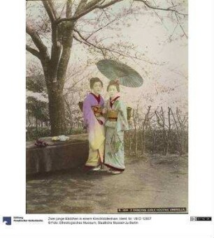 Zwei junge Mädchen in einem Kirschblütenhain