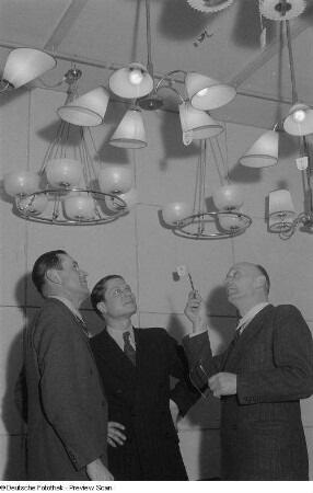 Besucher an einem Messestand mit Deckenlampen