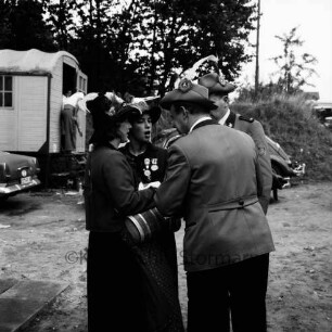 Schützenfest, 10-jähriges Jubiläum: Veranstalter Schützenverein Reinfeld und Umgebung von 1954 e.V.: zugleich Pokalschießen des Kreisschützenverbands Stormarn: Festplatz an der Ahrensböker Straße: zwei Schützen und zwei Marketenderinnen der Schützenkompanie Wilten (bei Innsbruck) mit hölzernen Schnapsfässchen: dahinter Wohnwagen, Autos, Böschung, 6. September 1964