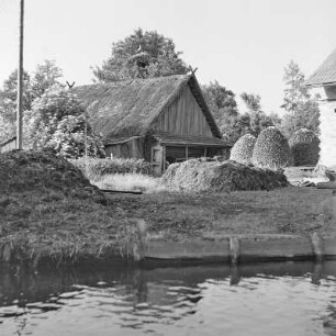 Blick auf ein mit Strohgedecktes Blockhaus mit Storchennest. : Wid na ze słomu pokrytu kładźitu chěžu z baćonjacym hnězdom.