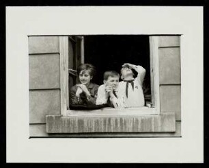 Zwei Jungs mit Pionierhalstuch und ein Mädchen mit FDJ-Hemd am Fenster, 1. Mai, Dessau