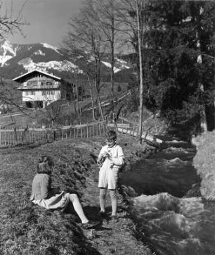 Kinderbilder. Allgäu im Frühling. Geschwisterpaar an einem Bach