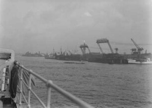Hamburger Hafen : Blick über die Reling eines Schiffs auf Hafenanlagen