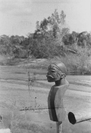 Mawesi-Fluss bei Tunduru : Detail. Landschaft mit einer Brücke über einen Fluss. An dem Geländer der Brücke sind Tonköpfe