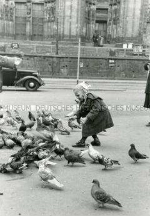 Kind mit Tauben vor dem Hauptbahnhof in Köln