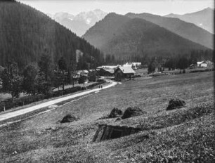 Beim Dorf : Ein Dorf in einem Tal. Im Vordergrund ein Schafstall am Berghang