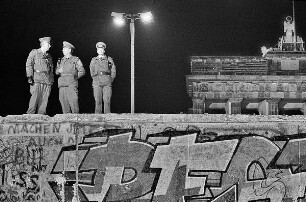 Drei Offiziere der Grenztruppen der DDR auf der Mauer am Brandenburger Tor