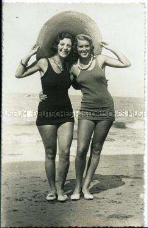 Zwei Frauen in Badeanzügen am Strand