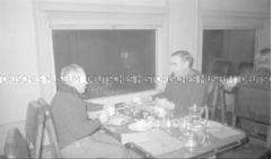 Selbstversenkung des Hochseepassagierdampfers "Columbus" am 19. Dezember 1939, Überführung von Besatzungsangehörigen vom Internierungslager auf Ellis Island in das Internierungslager auf Angel Island, Kalifornien, zwei Männer im Gespräch während einer Mahlzeit im Speisewagen