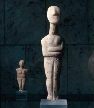 Stehendes weibliches Idol : München, Antikensammlung. Weibliches Idol, frühe Spedos-Art, frühkykladisch II. Trapezförmige Armhaltung. Beindurchbrechung. Im Hintergrund links: Weibliches Idol mit verschränkten Armen (Spedos-Art), Inv.Nr. 263