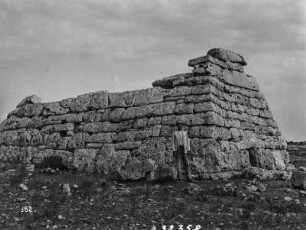 Naveta des Tudons : Person vor der Ruine einer prähistorischen Grablege bei Ciutadella
