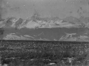 Gebirgszug : Panorama eines schneebedeckten Gebirgszugs vor einer Ebene im Tian Shan Hochgebirge