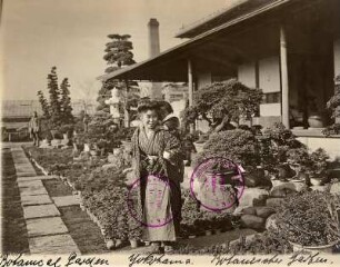 Yokohama. Botanischer Garten. Japanerin mit Kind auf dem Rücken im Bonsaigarten vor einem Gebäude