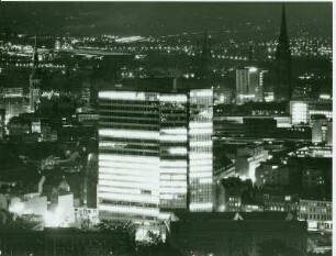 Hamburg-St. Pauli bei Nacht. Blick von der Hauptkirche St. Michaelis Richtung Mahnmal St. Nikolai. Im Vordergrund das beleuchtete IBM-Hochhaus
