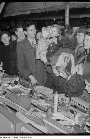 Kinder an einem Stand mit Holzspielzeug auf dem Weihnachtsmarkt