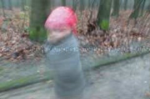 Unscharfes Foto eines im Wald laufenden Kindes mit rotem Tuch auf dem Kopf (Prämiertes Foto Sonderthema: Wunderland) (Altersgruppe SCH)