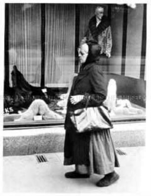 Alte Frau vor einem mondänen Schaufenster