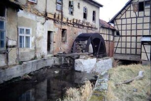 Gebäude der Mühle mit Mühlrad und Mühlgraben