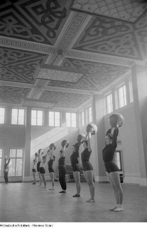 Sportlerinnen während einer Übung mit einem Medizinball in einer Sporthalle der Deutschen Hochschule für Körperkultur in Leipzig