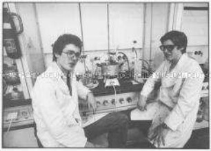 Zwei junge Männer mit Gerätschaften in einem Labor (Altersgruppe 18-21)