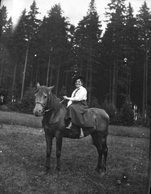 Frau im Damensitz auf einem Pferd