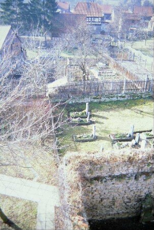 Blick vom Kirchturm auf Teil der Wehrmauer, Teil des Friedhofs und Gärten