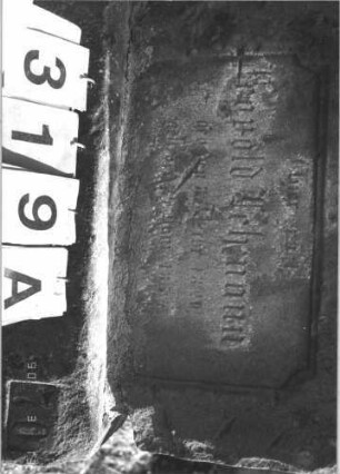 Grabstein 319 (Index: 99786307) Zustand: obere Hälfte auf Sockel zementiert, Vorderseite vollständig abgeblättert Maße HxBxT: 110x67x23 cm: Grabstein 319A