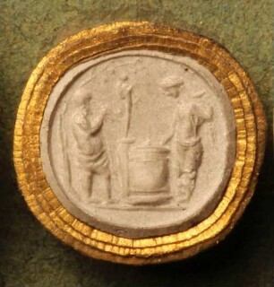 Eine Frau bringt vor einer Priapos-Herme ein Opfer dar, daneben ein Flötenspieler (Daktyliothek, Erstes Mythologisches Tausend)