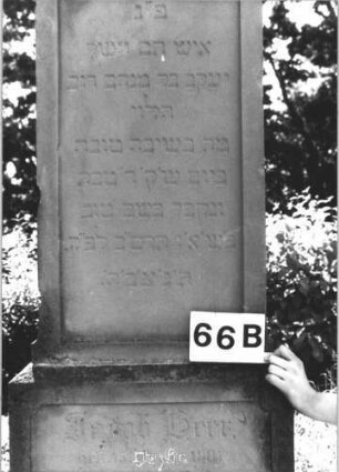 Grabstein 63 (Index: 99805298) Material: Sandstein Zustand: leicht verwittert Maße HxBxT: 182x69x41 cm Beschreibung: Stele, getreppter Sockel, Giebel mit stilisierten Eckakroteren, rechteckiges Schriftfeld eingetieft Symbolik: Blätterkranz im Giebel: Grabstein 63 (Detailaufnahme)