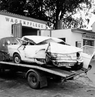 B 75: nach Verkehrsunfall bei Travenhof: Wrack von Unfall-Pkw auf Plattform von Abschleppwagen: auf Gelände von Tankstelle und Autowerkstatt "Stinnes", hinten Halle für "Wagenpflege"