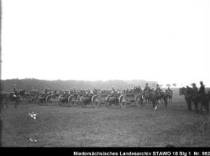 Besichtigung des Feld-Artillerie-Regiments Nr. 46 Enthält: Soldaten zu Pferd und auf mit Pferden bespannten Geschützlafetten reiten in Front vor Offizieren entlang