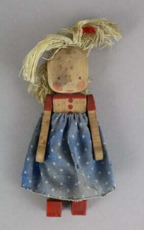 Kleines Püppchen im blaugepunkteten Kleid