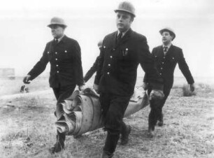 Feuerwehrleute beim Tragen eines Sperrschlauches zum Schutz vor Hochwasser