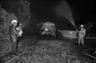 Freiwillige Feuerwehr Reinfeld: Kinderheim Sonnenschein: Giftgasunfall: vorn links Wehrführer Werner Gaethke mit Funkgerät: hinten rechts und links zwei Feuerwehrmänner in Schutzkleidung an Spritzen beim Errichten einer Wasserwand: dahinter Mitte verunglückter Tanklastwagen: Nacht