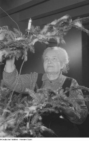 Porträt einer alten Frau an einem Weihnachtsbaum