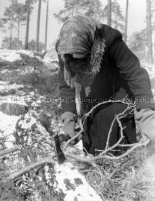 Frau bei Hacken von Brennholz