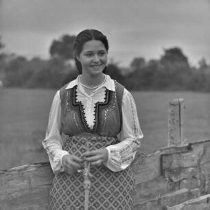Frau in bulgarischer Tracht übt das Handwerk des Spinnens aus