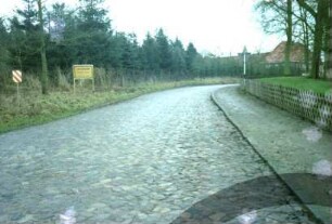 ehemaliges Gut Trenthorst-Wulmenau: Trenthorst: Straße mit Kopfsteinpflaster: hinten Ortsschild: im Hintergrund links Kopfbau Wirtschaftshof [Karree]