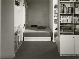 Doppelliege : Mustereinraumwohnung (1972; Deutsche Bauakademie). Ansicht mit Arbeitsecke, Doppelliege und Bücherschränken als Raumteiler