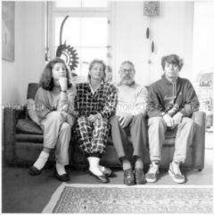 Familie mit zwei älteren Kindern sitzt auf dem Sofa (Sonderthema: Familien-Bilder)