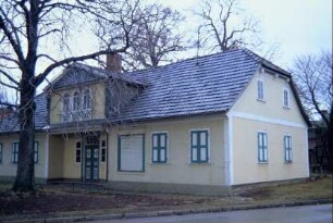 Geschäftshaus mit Zwerchgiebel, Putzfaschen, Fensterläden